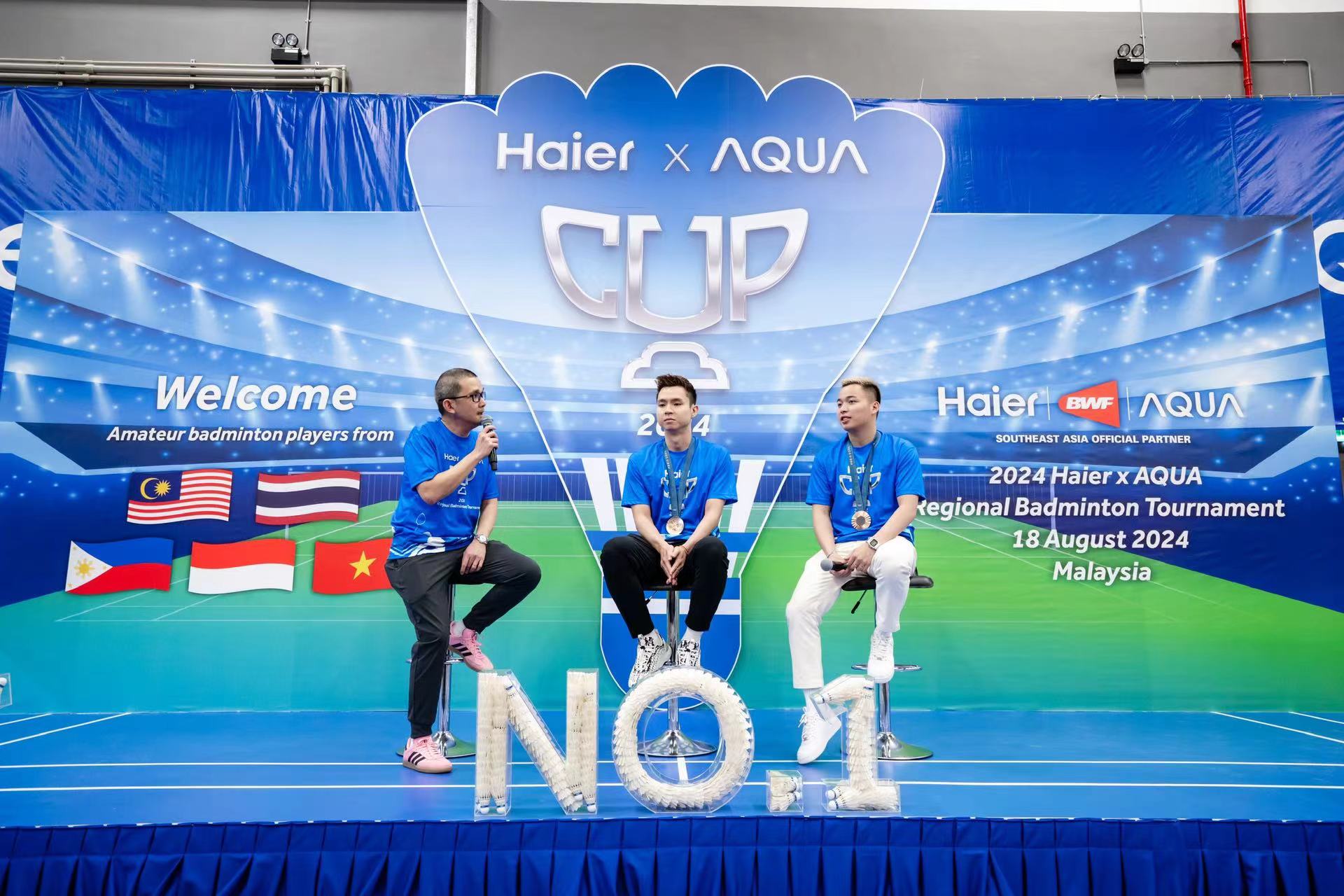 Haier Malaysia Brand Marketing Assistant Director Julian Thean speaking to brand ambassadors Aaron Chia and Soh Wooi Yik who made a special appearance following their Paris 2024 Olympic Games heroics to thrill participants